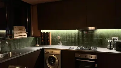a kitchen with a stove and a washer in it at Modern Japanese and Arabic Fusion City Stay that is 10 min from Dubai Mall in Dubai