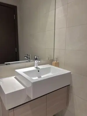 a bathroom with a white sink and a mirror at Modern Japanese and Arabic Fusion City Stay that is 10 min from Dubai Mall in Dubai