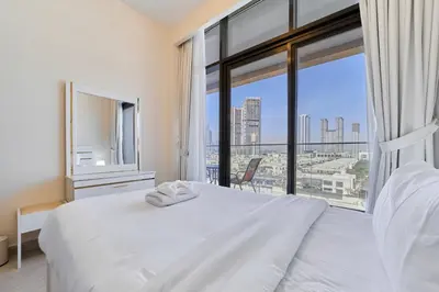 a bedroom with a white bed and a large window at Elegant 2BR Getaway in Azizi Riviera Near Downtown in Dubai