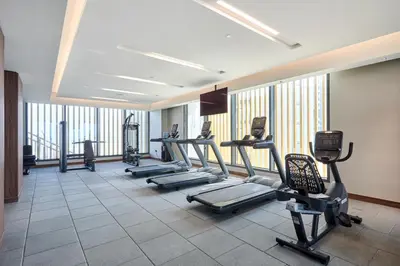 a gym with treadmills and machines in a room at STAY BY LATINEM Luxury 1BR Holiday Home CA 1605 Near Burj Khalifa in Dubai