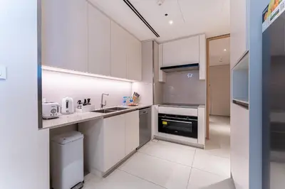 a white kitchen with white cabinets and appliances at HAVN - 3 Bedroom in The Address, JBR in Dubai