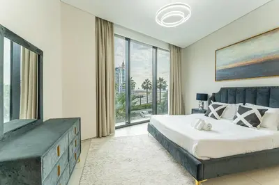 a bedroom with a large bed and a large window at HAVN - 3 Bedroom in The Address, JBR in Dubai