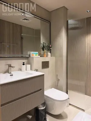 a bathroom with a toilet and a sink and a mirror at Amazing 4 BR on Palm Jumeirah with super sea view in Dubai
