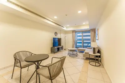 a living room with a table and chairs at HAVN - High Floor 2 Bedroom in Marina, near Tram in Dubai