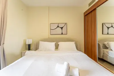 a bedroom with a large white bed and a mirror at HAVN - High Floor 2 Bedroom in Marina, near Tram in Dubai