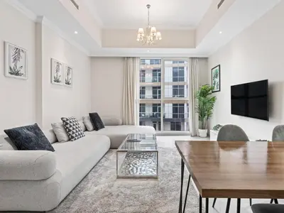 a living room with a couch and a table at Urban Elegance 1BDR in Dunya 06 in Dubai
