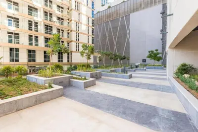 a courtyard in a building with trees and plants at Urban Elegance 1BDR in Dunya 06 in Dubai