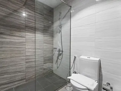 a bathroom with a toilet and a glass shower at Urban Elegance 1BDR in Dunya 06 in Dubai