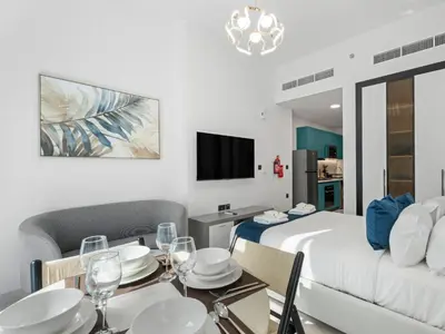 a room with a bed and a dining table and a bed at Opalz Solace Cozy Luxe Studio 03 in Dubai