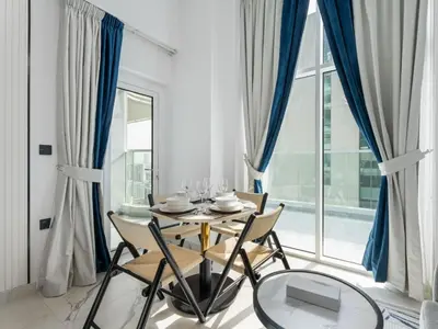 a dining room with a table and chairs and a large window at Opalz Solace Cozy Luxe Studio 03 in Dubai