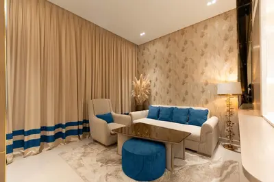a living room with a couch and a table and chairs at The Royal Blue Jacuzzi Suite 32 1-6-10 I JVC I Dar Oasis in Dubai