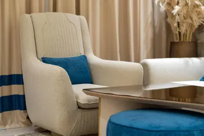 a living room with a chair and a table at The Royal Blue Jacuzzi Suite 32 1-6-10 I JVC I Dar Oasis in Dubai