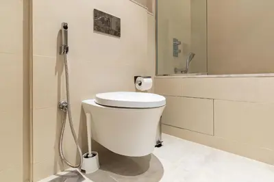 a white bathroom with a toilet and a shower at Downtown Dubai - Bright 1BR Apartment - Imperial Avenue in Dubai