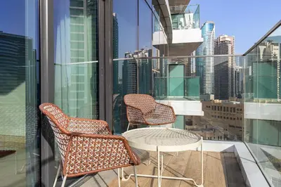 two chairs and a table on the balcony of a building at Downtown Dubai - Bright 1BR Apartment - Imperial Avenue in Dubai