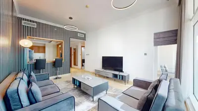 a living room with a couch and a tv at Vacationer l Cozy 1 Bed l Partial Sea View l Prime Location in Dubai