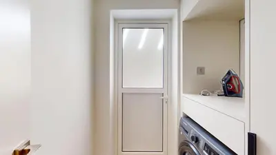 a laundry room with a door next to a washing machine at Vacationer l Opulent 2 Bedroom Villa l Private Plunge Pool in Dubai