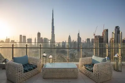 a balcony with two chairs and a table with a view of the city at Vacationer I Premium 2 Bedroom Apartment I Iconic Burj Khalifa View I Downtown I Distinction Tower in Dubai