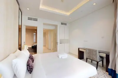 a bedroom with a white bed and a desk at Vacationer I Premium 2 Bedroom Apartment I Iconic Burj Khalifa View I Downtown I Distinction Tower in Dubai