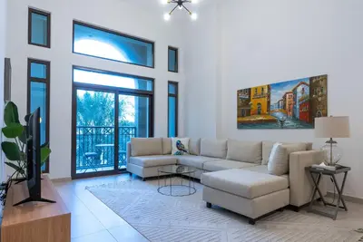 a living room with a couch and a tv at Jumeirah Stay Near To Beach in Dubai