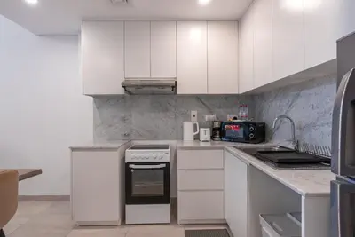 a kitchen with white cabinets and a stove top oven at Jumeirah Stay Near To Beach in Dubai
