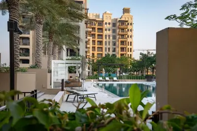 a pool with a table and chairs and buildings at Jumeirah Stay Near To Beach in Dubai