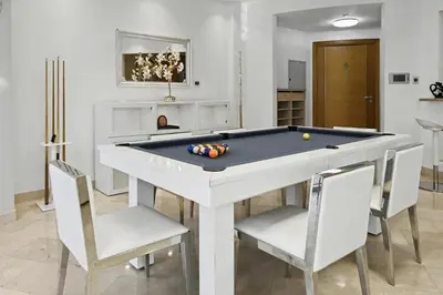 a living room with a pool table and chairs at Ultra-Luxury 3BR -Full Sea & Marina Views - JBR in Dubai