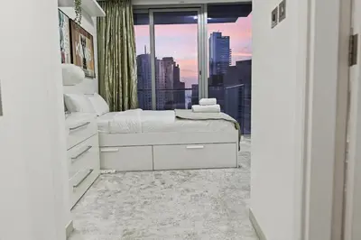 a bedroom with a bed with a view of a city at Ultra-Luxury 3BR -Full Sea & Marina Views - JBR in Dubai