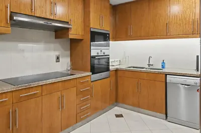 a kitchen with wooden cabinets and stainless steel appliances at Ultra-Luxury 3BR -Full Sea & Marina Views - JBR in Dubai