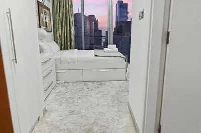 a bedroom with a bed and a view of a city at Ultra-Luxury 3BR -Full Sea & Marina Views - JBR in Dubai