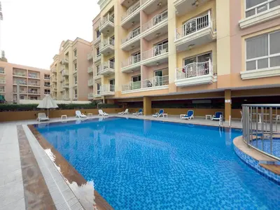 a large swimming pool in front of a building at Spacious 1BR Magnolia 1 JVC in Dubai