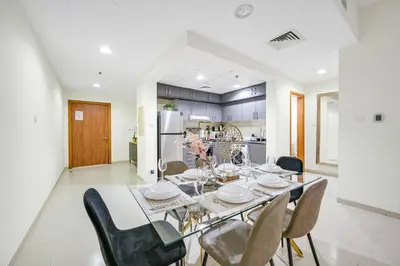 a kitchen and dining room with a table and chairs at Spacious 1BR Magnolia 1 JVC in Dubai