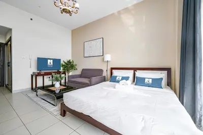 a bedroom with a large bed and a couch at Amazing Studio Glitz 1 Dubai Studio city in Dubai