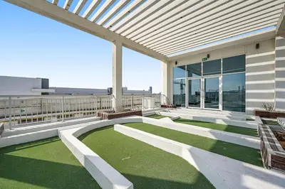 a patio with grass and benches on a building at Amazing Studio Glitz 1 Dubai Studio city in Dubai