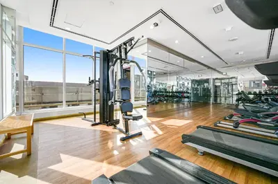 a gym with treadmills and exercise equipment in a building at Amazing Studio Glitz 1 Dubai Studio city in Dubai