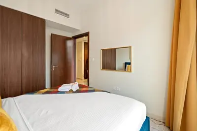 a bedroom with a white bed and a mirror at Stylish 1BR Burj Khalifa Fireworks View - Reva Residence in Dubai