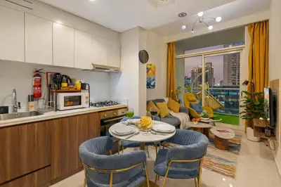 a kitchen and living room with a table and chairs at Stylish 1BR Burj Khalifa Fireworks View - Reva Residence in Dubai