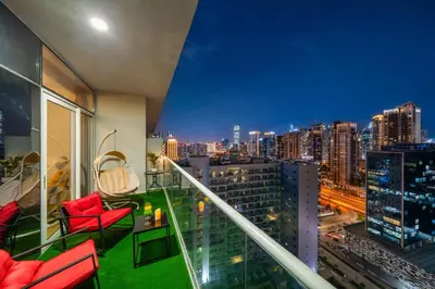 a balcony with red chairs and a view of a city at Stylish 1BR Burj Khalifa Fireworks View - Reva Residence in Dubai