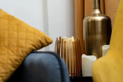 a close up of a couch with a vase and candles at Stylish 1BR Burj Khalifa Fireworks View - Reva Residence in Dubai