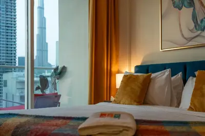 a bedroom with a bed with a view of a city at Stylish 1BR Burj Khalifa Fireworks View - Reva Residence in Dubai