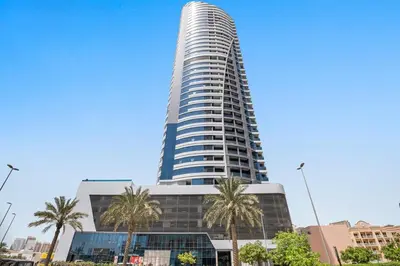 a tall building with palm trees in front of it at Balcony Breeze O2 with amazing high way view in Dubai
