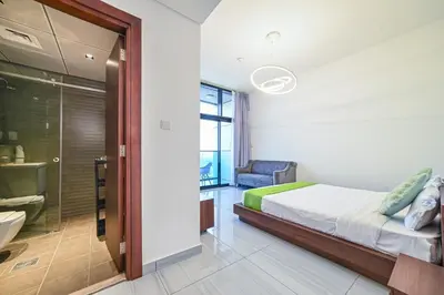 a bedroom with a bed and a sliding glass door at Balcony Breeze O2 with amazing high way view in Dubai