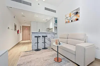 a living room with a couch and a table at Bloomfields Comfort Studio at Bali Residence, DXB in Dubai