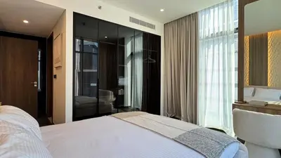 a bedroom with a bed and a large window at Huge Luxury Waterfront Duplex in Peninsula 5 in Dubai