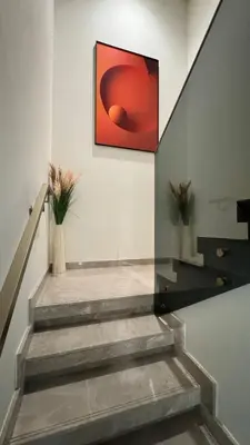 a staircase with a red painting on the wall at Huge Luxury Waterfront Duplex in Peninsula 5 in Dubai