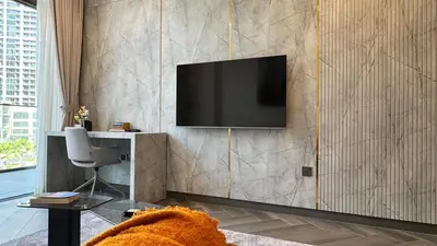 a living room with a television on a wall at Huge Luxury Waterfront Duplex in Peninsula 5 in Dubai
