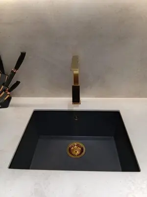 a black sink with a brass faucet over it at The Executive Suite Luxury 1 Bedroom Brand New in Dubai