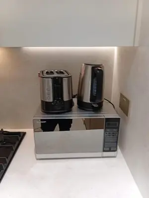 a microwave with a coffee maker on top of it at The Executive Suite Luxury 1 Bedroom Brand New in Dubai