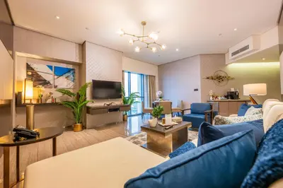 a living room with a blue couch and a tv at City View 1 BR - Creek Heights, Upgraded by UDH in Dubai