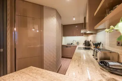 a kitchen with brown cabinets and a counter top at City View 1 BR - Creek Heights, Upgraded by UDH in Dubai