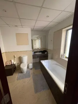 a large bathroom with a tub and a toilet at Two Bedroom Apartment with Excellent Location in Dubai
